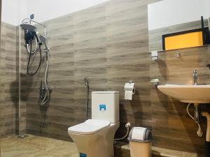 a bathroom with a toilet and a sink at Luminozo Beach Hotel in Weligama