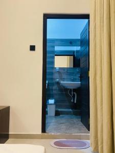 a bathroom with a sink and a toilet and a mirror at Luminozo Beach Hotel in Weligama