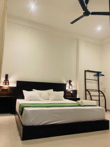 a bedroom with a large bed with a ceiling fan at Luminozo Beach Hotel in Weligama