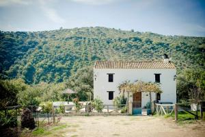 une petite maison blanche en face d'une montagne dans l'établissement Rancho Calvillo, à Prado del Rey