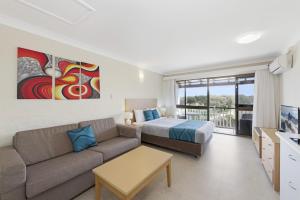 a living room with a couch and a bed at Don Pancho Beach Resort in Bargara