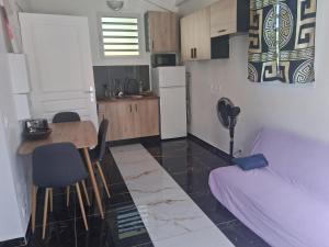 a small kitchen with a table and a couch at Kaz o ti plezi in Sainte-Rose