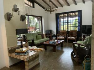 a living room with green couches and a table at Finca San Pablo in Subachoque