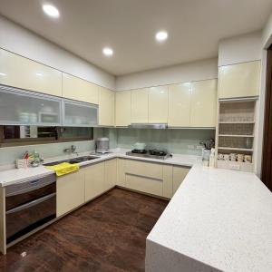 a large kitchen with white cabinets and white counter tops at Lingering Light #預定後請聯繫 in Tainan