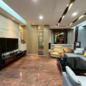 a living room with a couch and a tv at Lingering Light #預定後請聯繫 in Tainan