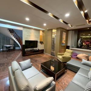 a living room with a couch and a table and a tv at Lingering Light #預定後請聯繫 in Tainan