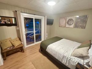 a bedroom with a bed and a large window at Maple Woods B&B in Honeymoon Bay