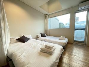 two beds in a room with a window at Haus128 in Sapporo +20 photos