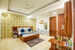 a bedroom in a hotel with a bed and a table at Hotel Fabulous - Delhi International Airport in New Delhi