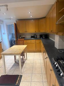 a kitchen with wooden cabinets and a wooden table at Near city centre, Derby train station and royal Derby hospital in Derby