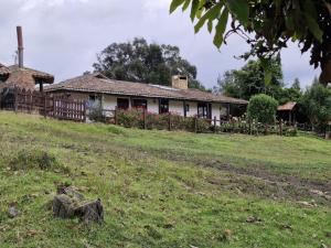 a house on a hill with a grass field at Finca San Pablo in Subachoque