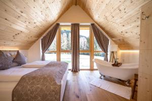 a bedroom with a bed and a tub next to a window at Ebner 1822 in Gnesau
