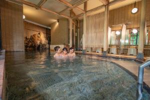 three children in a swimming pool in a building at Ooedo Onsen Monogatari Yamanaka Saichoraku in Kaga