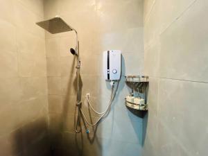 a shower in a bathroom with a phone on the wall at Green Island Bungalows in Kampot +20 photos