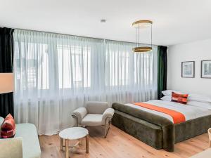 a bedroom with a large bed and a chair at Chic City Apartment, 1BR for 2, Elegant Comfort, City Center in Wuppertal