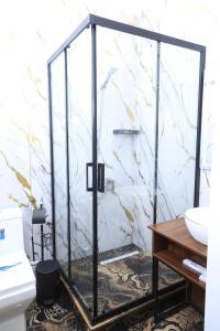 a glass shower in a bathroom with a sink at FIRDAVS HOTEL in Navoi