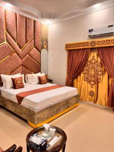 a hotel room with a bed and a table at Galaxy Rezidor in Karachi