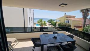 a balcony with a table and chairs and a view of the ocean at Dinary Apartman in Vir