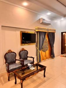 a living room with two chairs and a coffee table at Galaxy Rezidor in Karachi