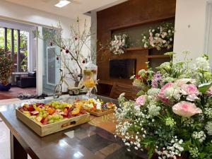 a table with a tray of fruit and flowers at Spuds&Bunks Hostel in Hanoi