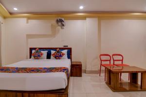 a bedroom with a bed and a table and chairs at FabHotel Iubit in kolkata