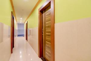 a hallway with a wooden door in a room at FabHotel Iubit in kolkata +24 photos