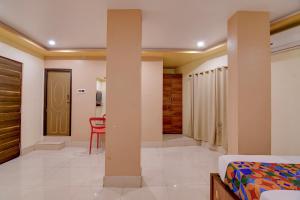 a bedroom with a bed and a table and a chair at FabHotel Iubit in kolkata