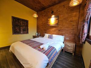 a bedroom with a large bed with a wooden wall at PiTu Homestay in Dồng Văn +26 photos