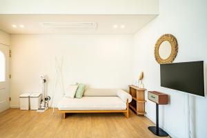 a living room with a white couch and a flat screen tv at Stay Cherry in Seogwipo