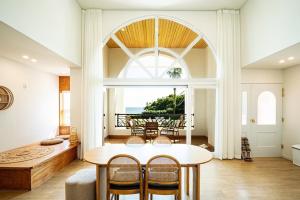 a dining room with a table and a large window at Stay Cherry in Seogwipo