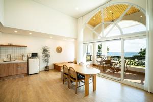 a kitchen and dining room with a table and a view of the ocean at Stay Cherry in Seogwipo +13 photos