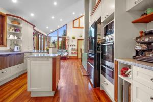 a large kitchen with white cabinets and a large window at Paradise in the city in Christchurch