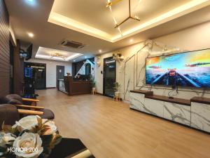 a living room with a large flat screen tv on a wall at TK Thongrak Apartment in Hat Yai