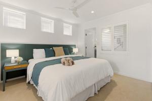 a bedroom with a large bed with a stuffed animal on it at Oceanview Oasis in Urangan