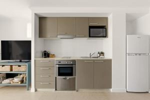 a kitchen with stainless steel appliances and a refrigerator at Oceanview Oasis in Urangan