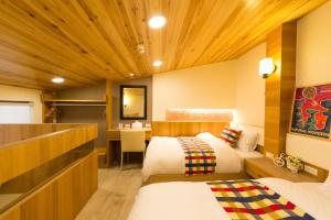 a hotel room with two beds and a desk at W Hostel in Tainan