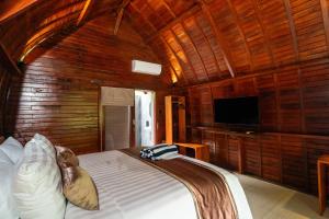 a bedroom with a bed in a wooden room at Udaka Retreat in Payangan