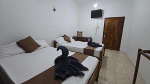 two swans sitting on two beds in a room at Stay Suite in Mahiyangana
