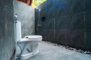 a bathroom with a shower and a toilet in it at Udaka Retreat in Payangan