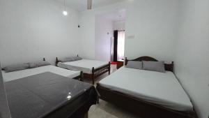 a room with two beds and a window at Stay Suite in Mahiyangana