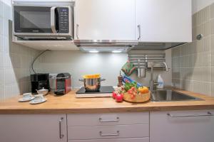a kitchen counter with a sink and a bowl of fruit at Il nido nella Pineta Central in Ski resort - Happy Rentals in Bardonecchia +20 photos