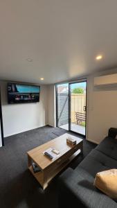 a living room with a couch and a coffee table at Tiny Home in Mosgiel in Mosgiel