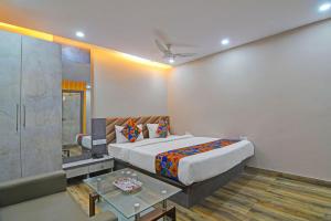 a bedroom with a king sized bed and a table at FabHotel Disa in kolkata +22 photos