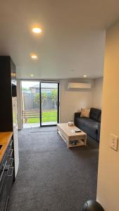 a living room with a couch and a table at Tiny Home in Mosgiel in Mosgiel
