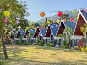 a row of houses with colorful lanterns hanging from their roofs at The Jungle Walker Resort in Rishīkesh