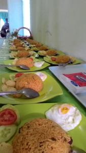 a table with green plates of food on it at Ruqita Homestay in Airtabit
