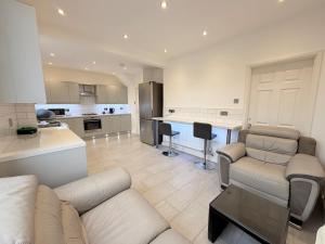 a living room with a couch and a kitchen at Precious House 2 in Leicester