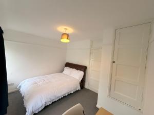 a bedroom with a white bed and a door at Precious House 2 in Leicester