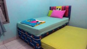 a childs bed with a pillow on top of it at Ruqita Homestay in Airtabit