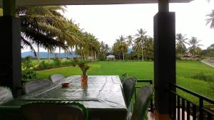 a table on a porch with a view of a field at Ruqita Homestay in Airtabit
